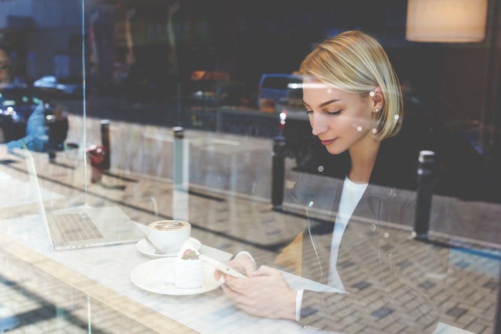 V Digital Services - Woman Checking Facebook Feed On Mobile Phone